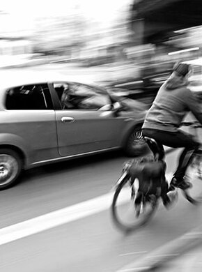 Mobilitaet, Verkehr, Radfahrer auf Radweg an Straße mit Auto